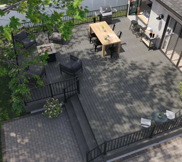 Aerial view of a multi-level charcoal grey composite deck with black aluminum railings, outdoor dining, fire pit, grill station, and lounge area on a suburban home