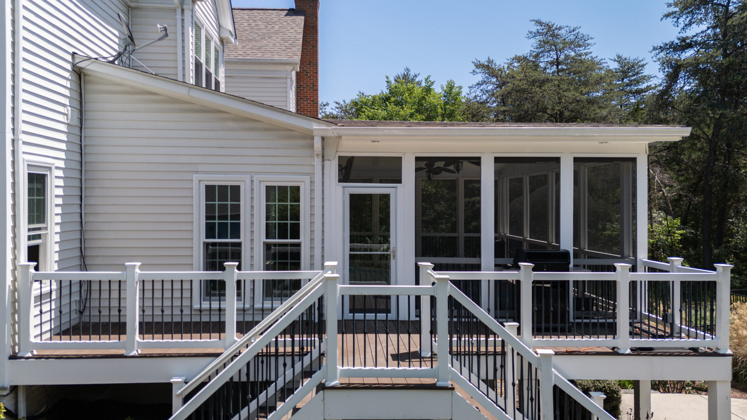 Aerial rear view of Centreville VA home after full window replacement by Noverra Exteriors, showing screened porch and elevated deck