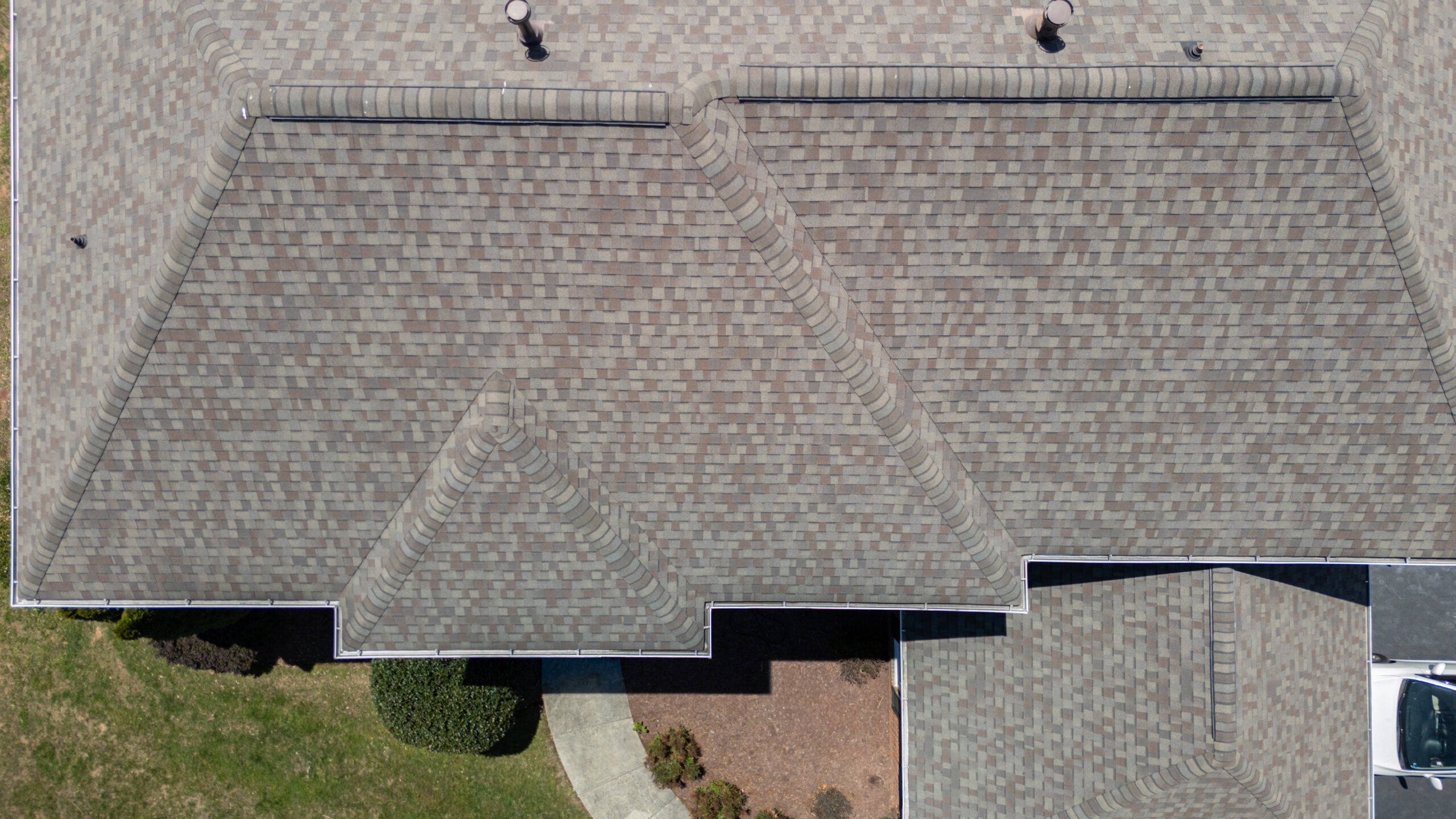 Aerial drone view of a multi-tone shingle roof replacement in Centreville, VA, highlighting a complex hip roofline with multiple valleys.