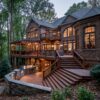 Multi-level composite deck in Langley Farms, McLean, VA with a stone outdoor kitchen, a pergola with string lights, and a wooded backyard setting.